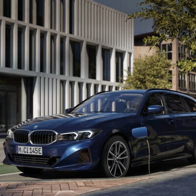 Ein BMW 3er Touring Plug in Hybrid steht an der Straße und wird geladen.