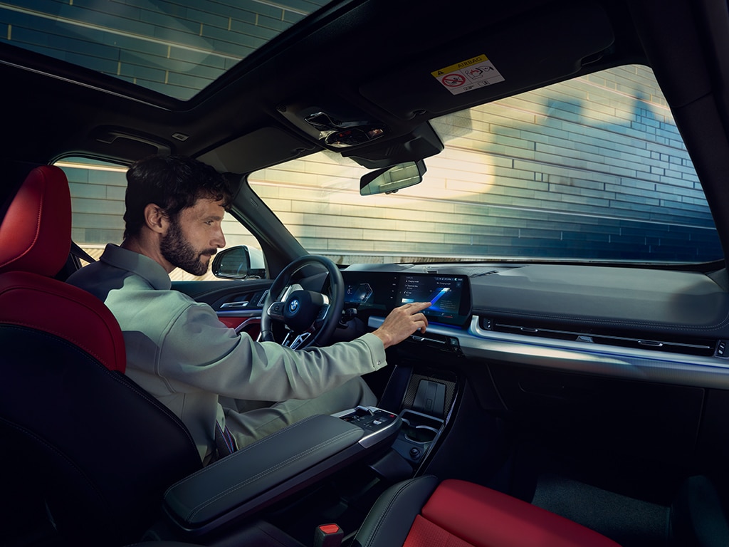 Mann im BMW iX1 und stellt was auf dem Display ein