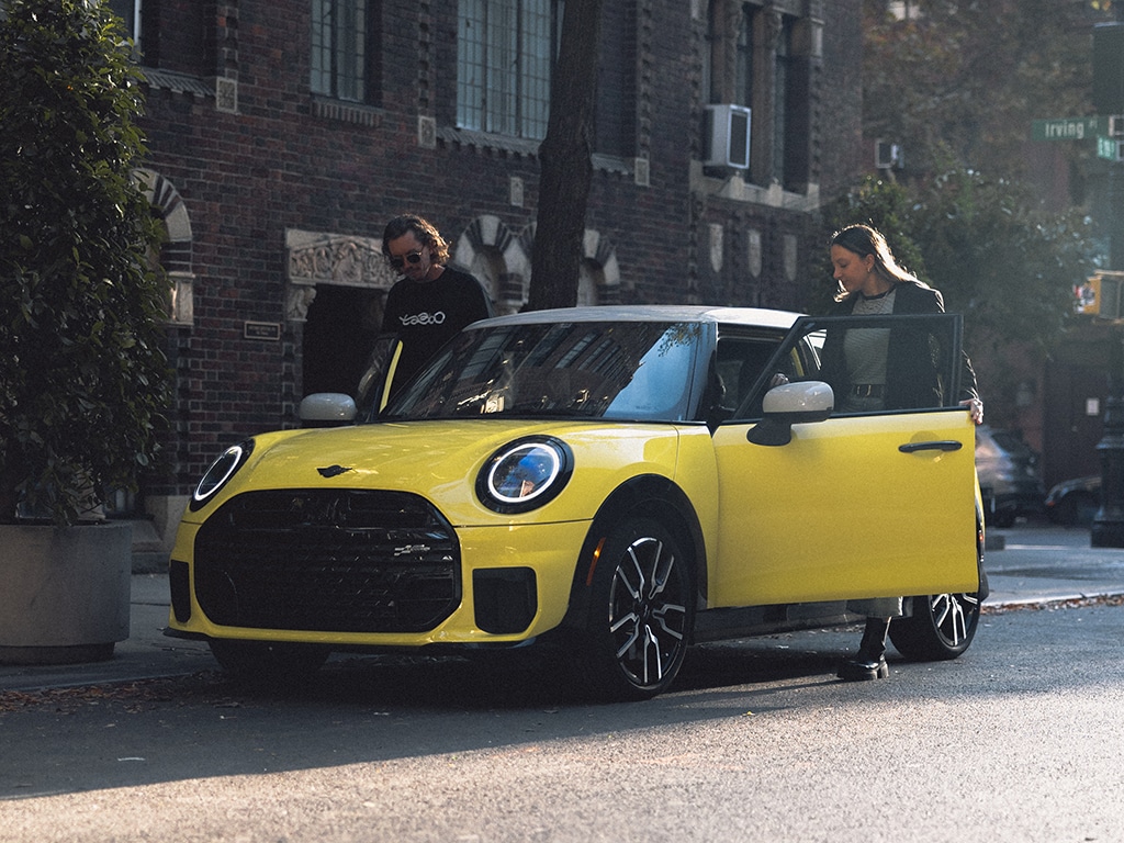 MINI Junge Gebrauchte, gelber MINI mit geöffneten Türen im urbanen Umfeld