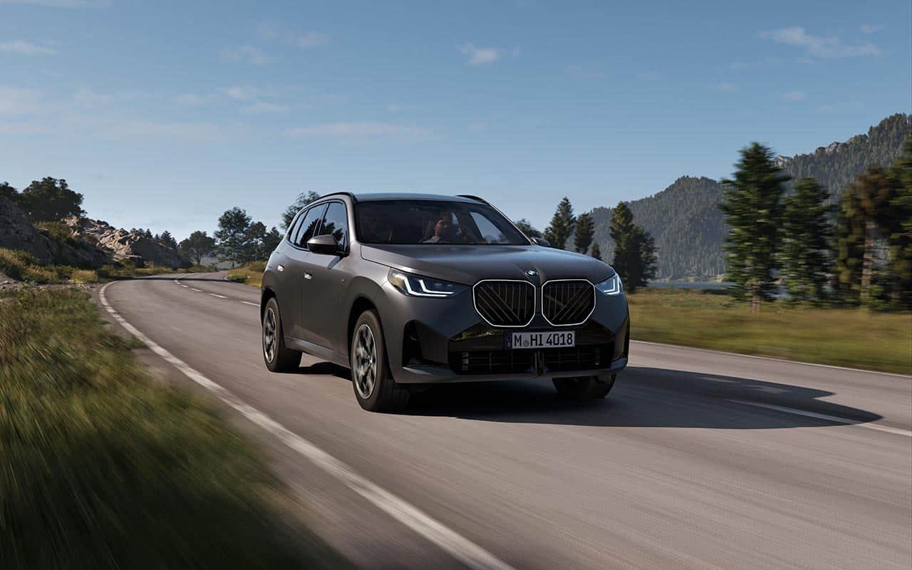 BMW X3 während der Fahrt auf einer Landstraße in Grau